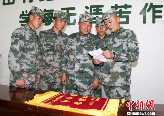 图为姚丁(左三)与战友一起在看感谢信。　刘晓东 摄