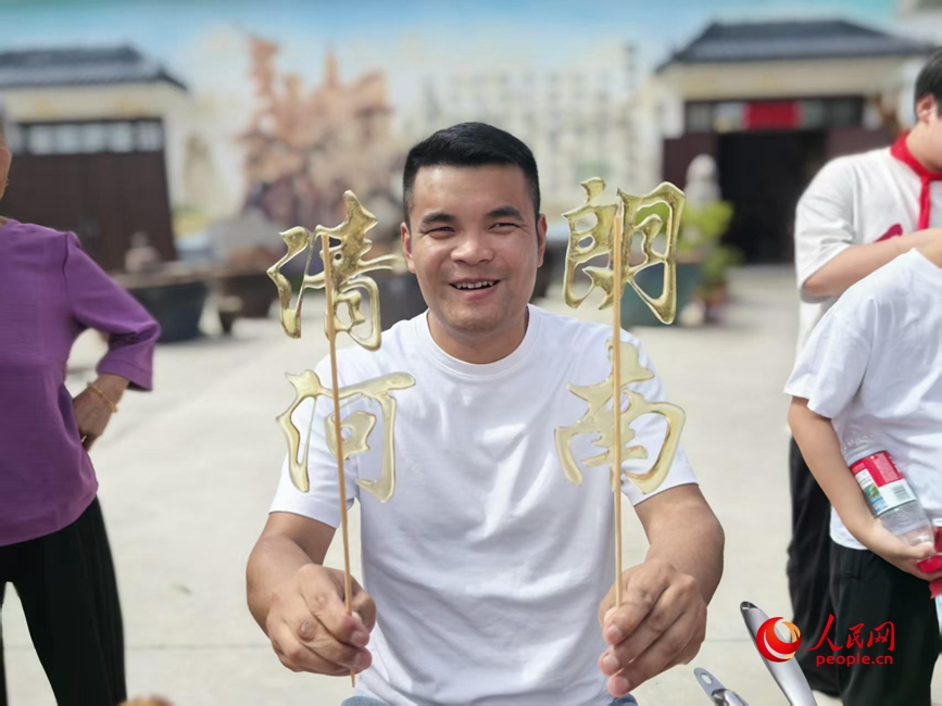 乡村大集上，摊主用麦芽糖做了&ldquo;清朗河南&rdquo;的糖画。人民网记者 王佩摄